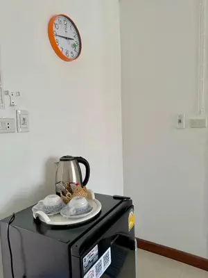 a clock and a tea pot on top of a microwave at Baan Alisa 12 in Nonthaburi