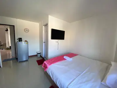 a bedroom with a bed and a tv on the wall at Baan Alisa 12 in Nonthaburi