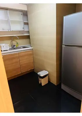 a small kitchen with a refrigerator and a sink at Omni Tower Nana- Fully Furnished Apartments Bangkok in Bangkok