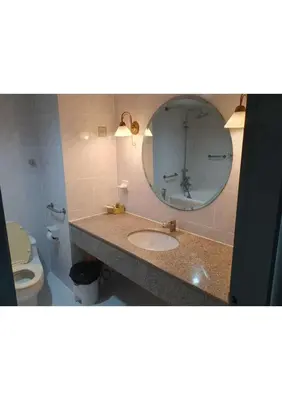a bathroom with a sink and a mirror and a toilet at Omni Tower Nana- Fully Furnished Apartments Bangkok in Bangkok