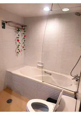 a bathroom with a bath tub and a toilet at Omni Tower Nana- Fully Furnished Apartments Bangkok in Bangkok