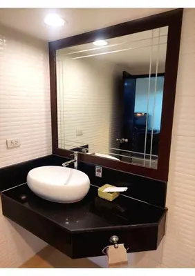 a bathroom with a sink and a large mirror at Omni Tower Nana- Fully Furnished Apartments Bangkok in Bangkok