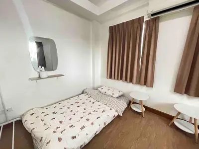 a small bedroom with a bed and a tv at Modern 5-Bedroom Townhome near MRT and Local Charm in Bangkok