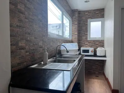 a kitchen with a sink and a brick wall at Above Heaven - 4BR for 12 Pax near MRT Ratchadapisek in Bangkok
