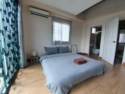 a bedroom with a large bed and a bathroom at Above Heaven - 4BR for 12 Pax near MRT Ratchadapisek in Bangkok