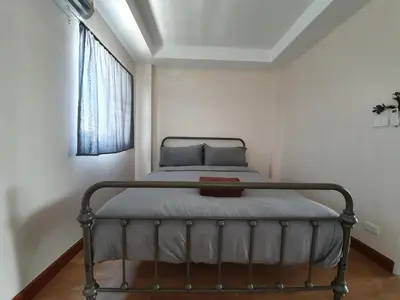 a bed in a white room with a window at Above Heaven - 4BR for 12 Pax near MRT Ratchadapisek in Bangkok