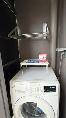 a washing machine with a shelf on top of it at 1BR Thonglor BTS InfinityPool overlooking city in Bangkok