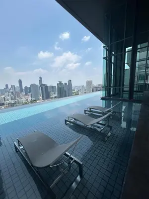 a swimming pool with two lounge chairs on a building at 1BR Thonglor BTS InfinityPool overlooking city in Bangkok