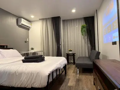 a hotel room with a bed and a chair at Cozy Mini Theatre - Victory Monument - 3 pax in Bangkok