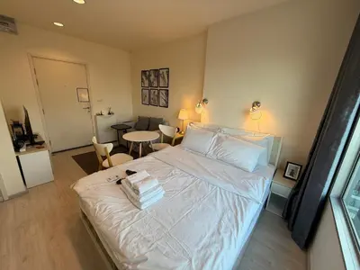 a bedroom with a bed and a table and chairs at Cozy5Living in Bangkok 60m to MRT near chatuchank in Ban Bang Khwang