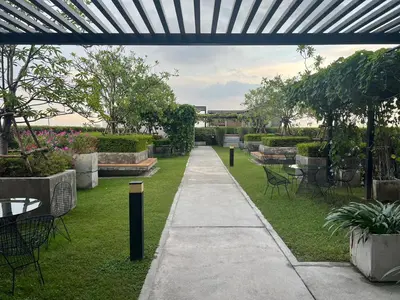 a walkway in a garden with tables and chairs at Cozy5Living in Bangkok 60m to MRT near chatuchank in Ban Bang Khwang