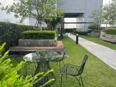 a patio with a table and chairs on the grass at Cozy5Living in Bangkok 60m to MRT near chatuchank in Ban Bang Khwang