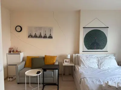 a bedroom with a bed and a couch and a clock at Cozy7 Living in Bangkok60 m to MRTnear chatuchank in Ban Bang Khwang
