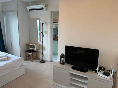 a living room with a flat screen tv on a cabinet at Cozy7 Living in Bangkok60 m to MRTnear chatuchank in Ban Bang Khwang