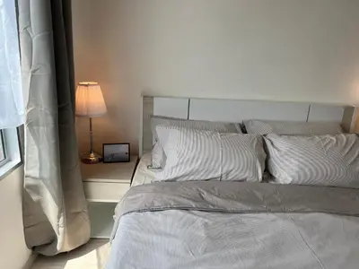 a bed with white sheets and pillows in a bedroom at Cozy6 Living in Bangkok 60m to MRT near chatuchank in Ban Bang Khwang