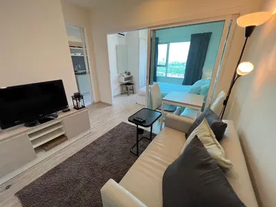 a living room with a couch and a flat screen tv at Cozy8Living in Bangkok 60mto MRT in Ban Bang Khwang