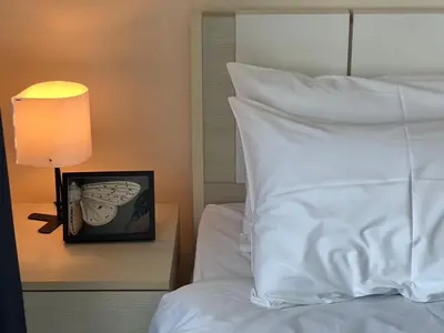 a bed with a lamp and a picture on a night stand at Cozy8Living in Bangkok 60mto MRT in Ban Bang Khwang