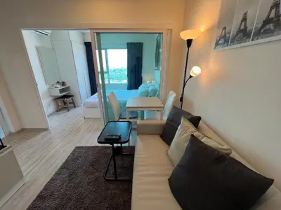 a living room with a couch and a table with a laptop at Cozy9Living in Bangkok 60mto MRT in Ban Bang Khwang