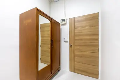 a wooden door in a room with a mirror at WJ Luxury Sathorn in Bangkok