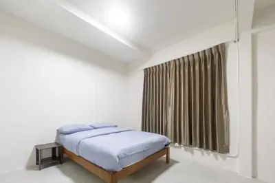 a white bedroom with a bed and a window at WJ Luxury Sathorn in Bangkok