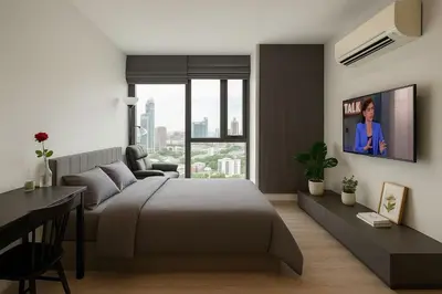 a bedroom with a bed and a tv on a wall at BTS Thonglor Skyline Condo in Bangkok