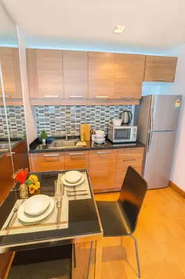 a kitchen with a glass table and a stainless steel refrigerator at Great Balcony with 2 Beds Executive Unit in Bangkok