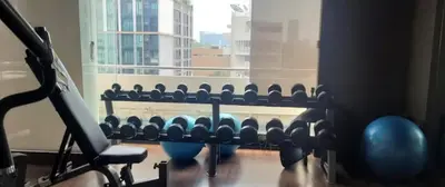 a row of dumbbells in a gym with a window at Great Balcony with 2 Beds Executive Unit in Bangkok