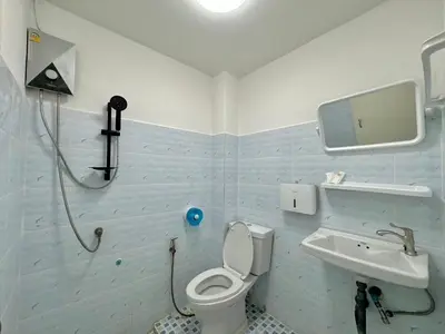 a bathroom with a white toilet and a sink at Baan alisa 13 in Nonthaburi