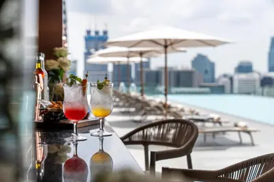 two wine glasses sitting on a table on a rooftop at Grande Centre Point Prestige Bangkok in Bangkok