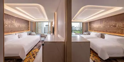 a row of beds in a room with windows at Grande Centre Point Prestige Bangkok in Bangkok