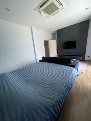 a bedroom with a blue bed and a tv at Maxim in Pak Kret