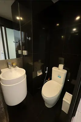 a bathroom with a white toilet and a sink at BTS Thong Lor Top Floor City View in Bangkok
