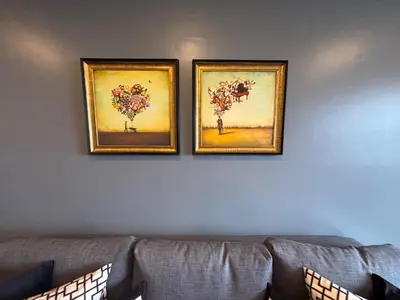 three framed paintings on a wall above a couch at Chic Bangkok Escape & Fast Wifi in Bangkok