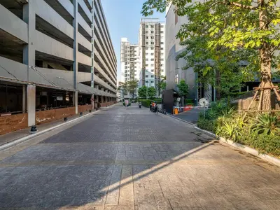 an empty street in a city with tall buildings at A space by cream in Bangkok