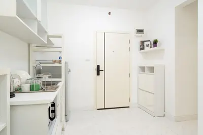 a kitchen with white walls and a door in a room at A space by cream in Bangkok