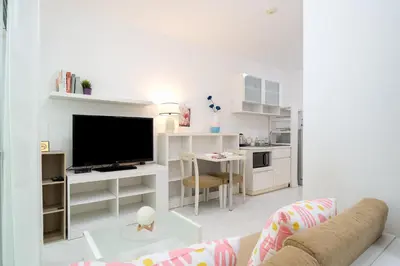 a white living room with a couch and a tv at A space by cream in Bangkok