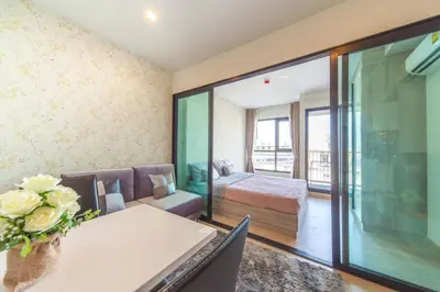 a room with a table and a bed and a bedroom at Knightsbridge Duplex Tiwanon by Natcha in Nonthaburi