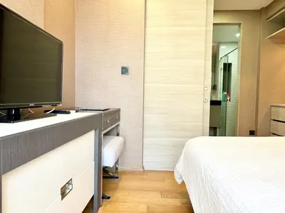 a hotel room with a television and a bed at Klass Langsuan Condo in Bangkok