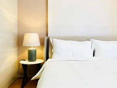a bedroom with a bed and a lamp on a table at Klass Langsuan Condo in Bangkok