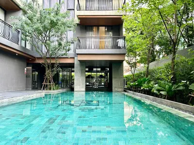 a swimming pool in front of a building at Klass Langsuan Condo in Bangkok