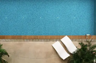 two white chairs sitting next to a swimming pool at Cozy stylish home near Nana BTS in Bangkok