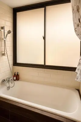 a white bath tub in a bathroom with a window at Cozy stylish home near Nana BTS in Bangkok