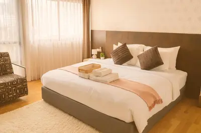 a bedroom with a large white bed with a box on it at Cozy stylish home near Nana BTS in Bangkok