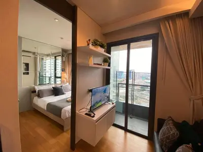 a bedroom with a bed and a laptop on a desk at River View Modern 1BR - Weekly Cleaning - Phrom Phong in Bangkok