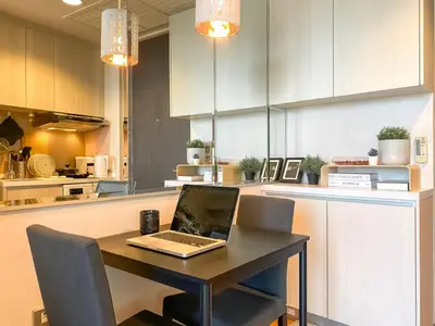 a laptop computer sitting on a table in a kitchen at River View Modern 1BR - Weekly Cleaning - Phrom Phong in Bangkok