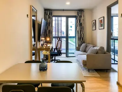 a living room with a table and a couch at Modern-Design Apt 45 sqm - Ultra Fast WiFi - Ekamai in Bangkok