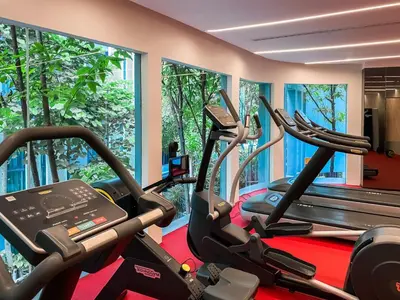 a gym with three cardio machines in a room at Modern-Design Apt 45 sqm - Ultra Fast WiFi - Ekamai in Bangkok