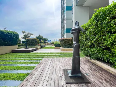 a bronze statue on a wooden floor in front of a building at Near BTS Thong Lor l Workspace and Kitchen l Sontana in Bangkok