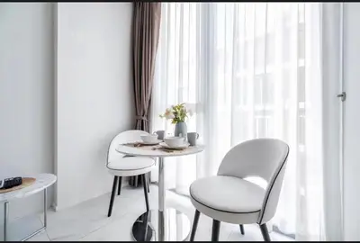 two chairs and a table in a room with a window at Hyde Sukhumvit 11 Bankok in Bangkok