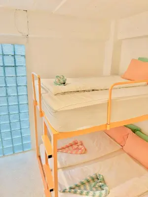 two bunk beds in a room with a window at Lazy Sunday Khaosan Hotel in Bangkok